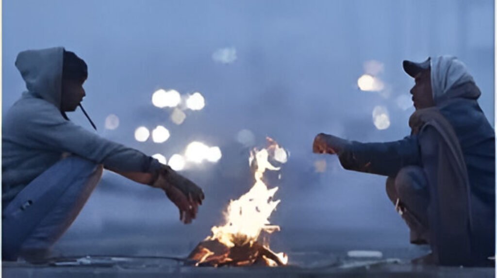 A man warms himself by a fire near Jama Masjid during Delhi’s coldest winter day of 2026.