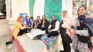Women gig workers in uniforms wait between app-based household service assignments in Noida.