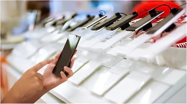 Customers browse refurbished smartphones in a store as demand rises amid rising new phone prices.