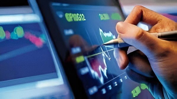 Traders track falling indices on a screen as Sensex and Nifty slip sharply in late trade, led by losses in Adani Group stocks.