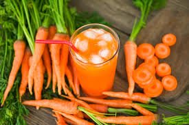 A glass of fresh carrot juice with sliced carrots, perfect for a healthy morning routine.