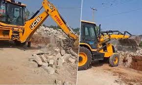 HYDRAA officials remove an illegally constructed compound wall at Kachavani Singaram in Medipally, restoring the public road to its full width.